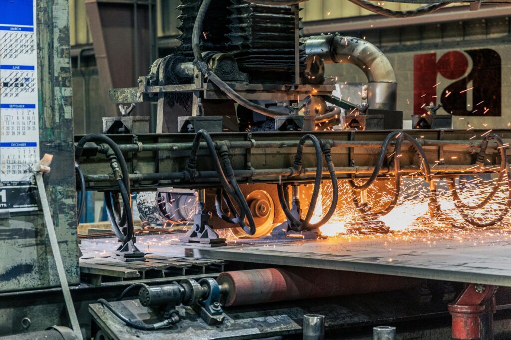 Detailed view of industrial machinery cutting metal, showcasing sparks and heat.